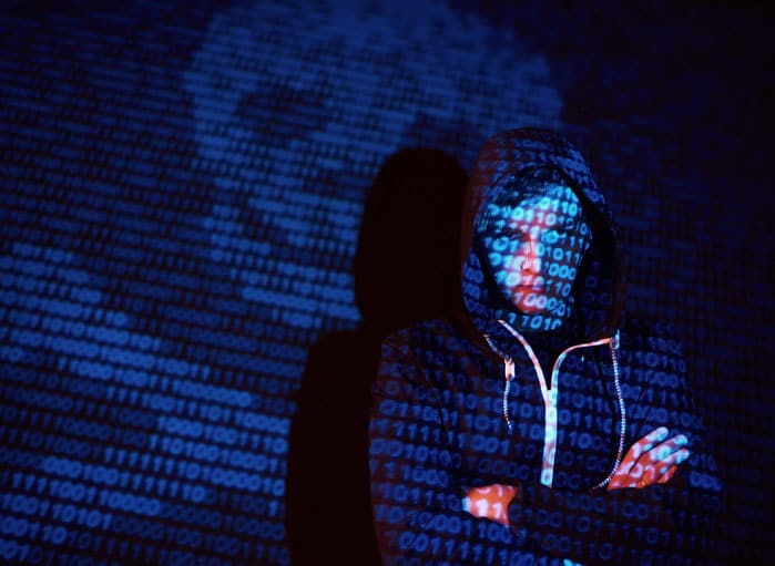 cyber-attack-with-unrecognizable-hooded-hacker-using-virtual-reality-digital-glitch-effect-scaled